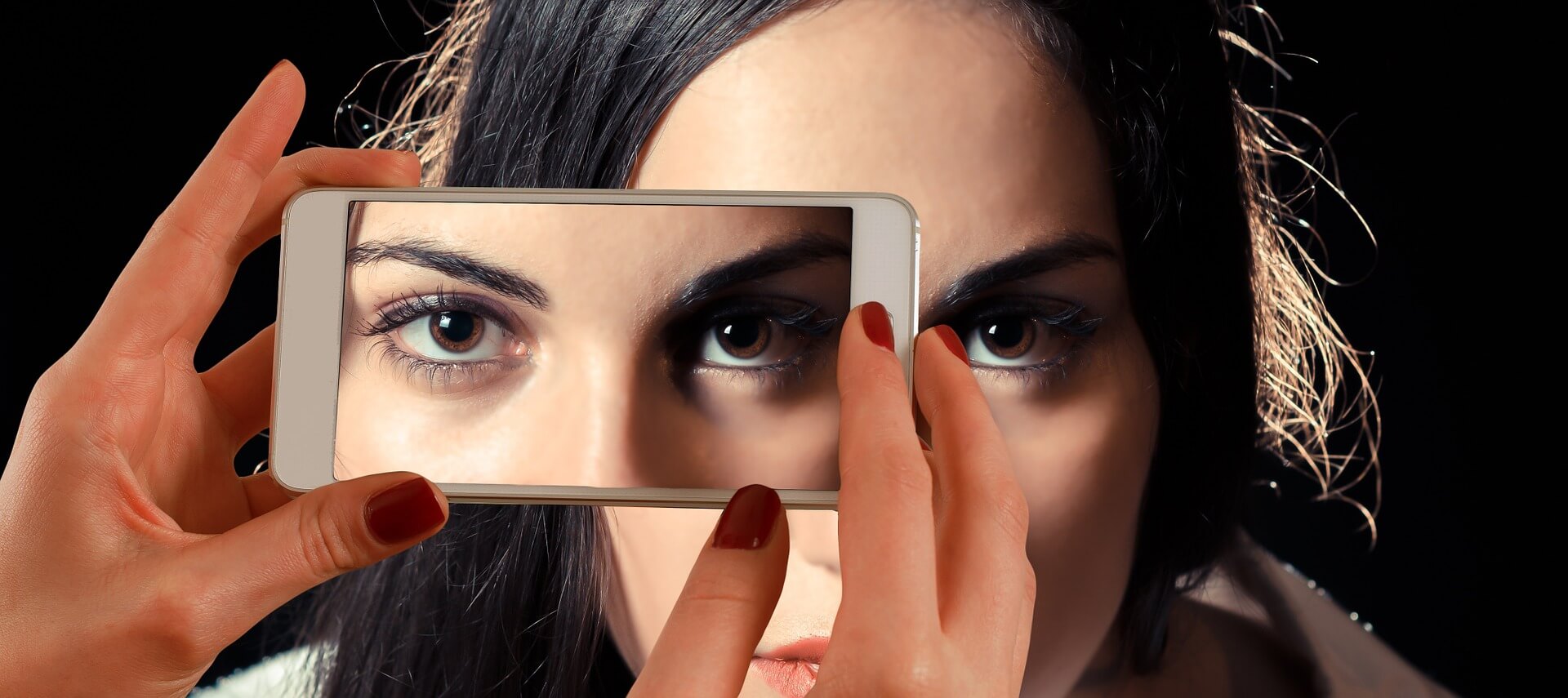 imagem sem autorização 1 - imagem de uma pessoa tirando uma foto com um celular do rosto de uma mulher