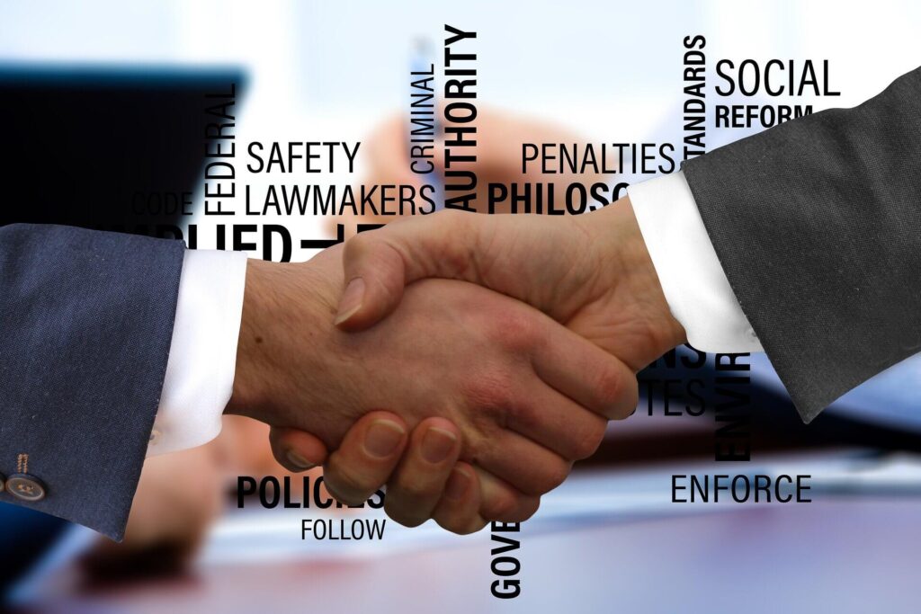 contrato social 1 - imagemde dois executivos de terno apertando as mãos