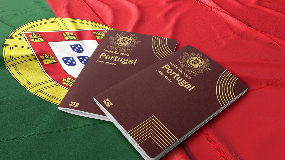 Como tirar a cidadania portuguesa sozinho 6 - Imagem de uma bandeira de Portugal e de dois passaportes portugueses