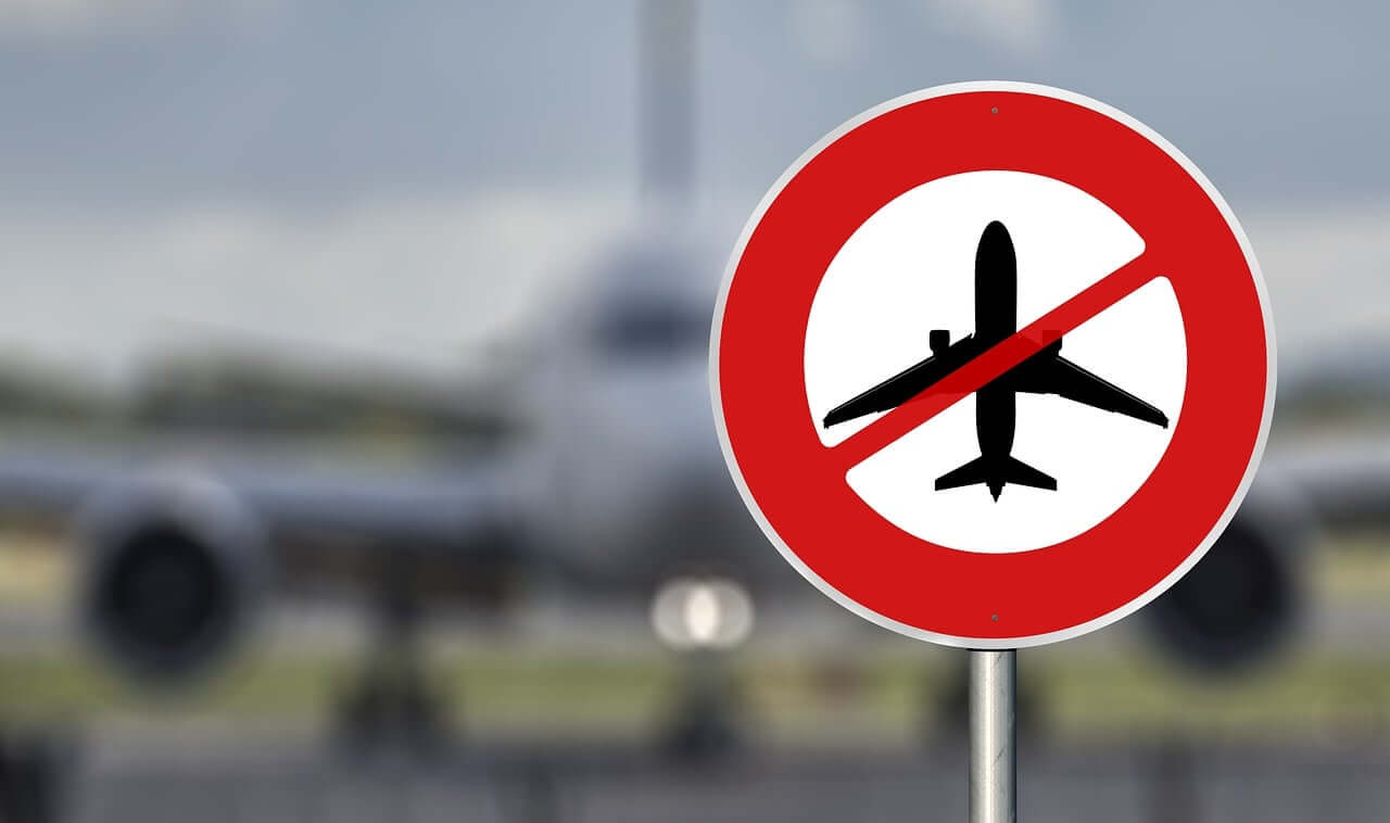 123 Milhas - Imagem de um avião com uma placa com desenho de um avião na frente com proibição