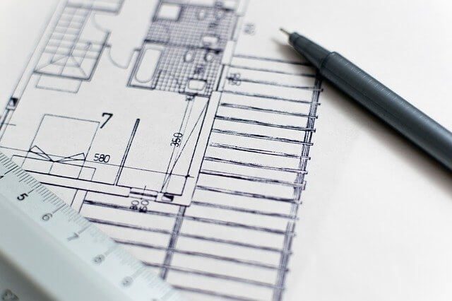 comprar imóvel 2 - imagem de uma planta de um imóvel desenhada em um papel branco e uma caneta preta sobre o papel